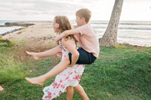 Sister gives brother a piggy back ride