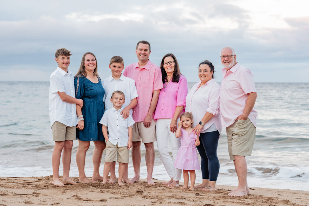 A multi-generational family poses on Wailea Beach at sunrise, captured by an affordable Maui photographer.