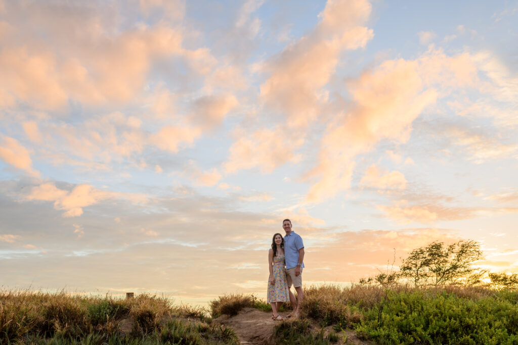 A couple poses during their sunrise Maui engagement session at Sugar Beach Maui.