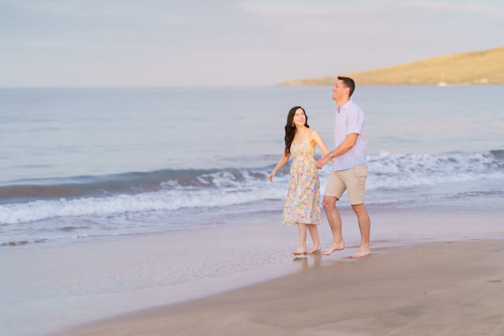 Maui engagement photographer captures 
a couple walks hand in hand along a peaceful beach on Maui.