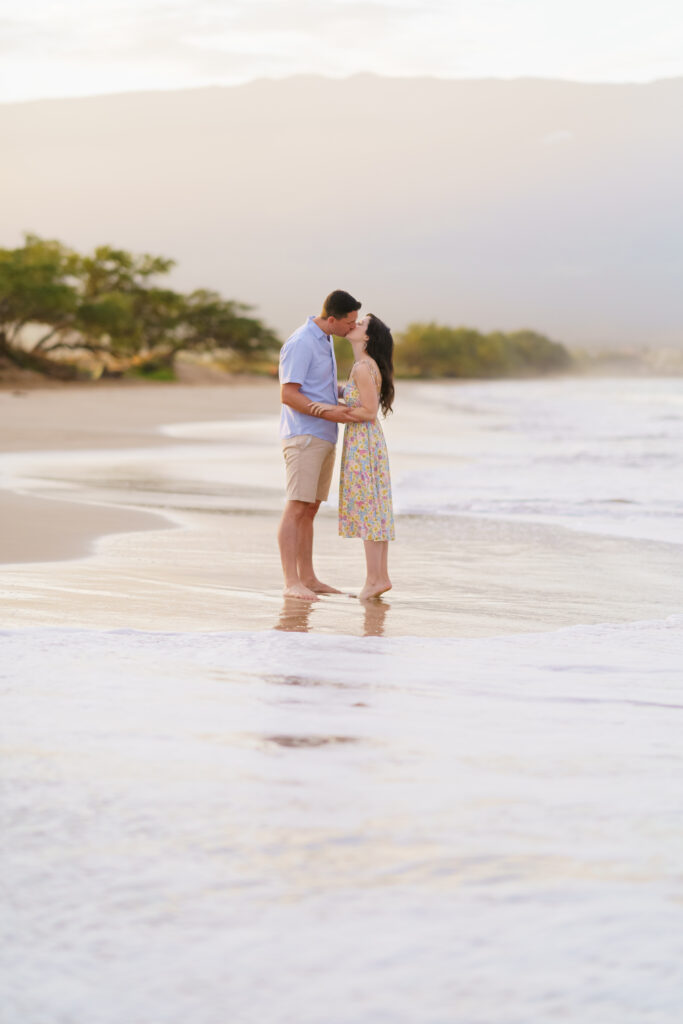 A couple shares a romantic kiss during their engagement session on Sugar Beach Maui.







